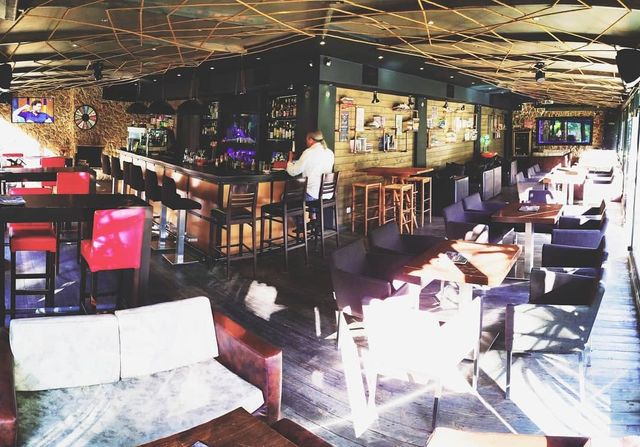 Inside Cozy Cafe & Bar: the bar, tables and armchairs